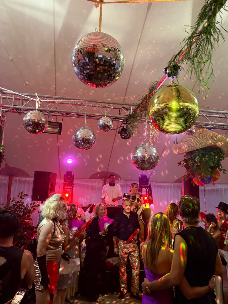 Feest in een tent met discoballen en roze sfeerverlichting
