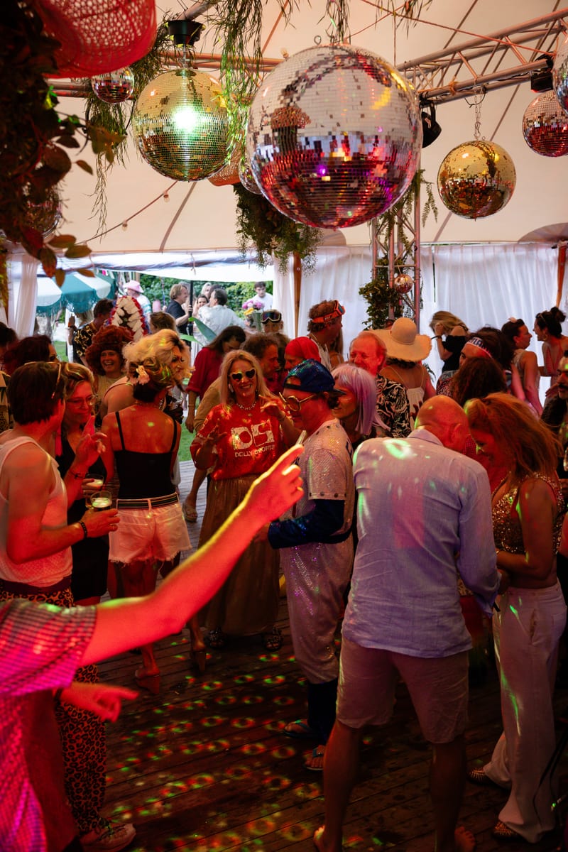 Dansvloer in een feesttent met discoballen aan het plafond