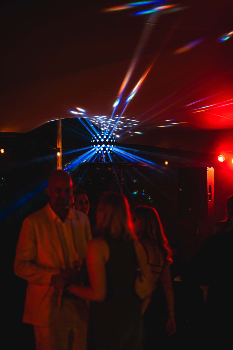 Blauwe lichtstralen boven het publiek tijdens een avondfeest